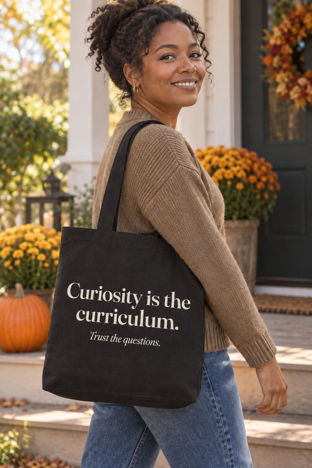 Curiosity is the curriculum. organic canvas market tote in Black, carried on the shoulder