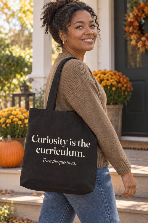 Curiosity is the curriculum. organic canvas market tote in Black, carried on the shoulder