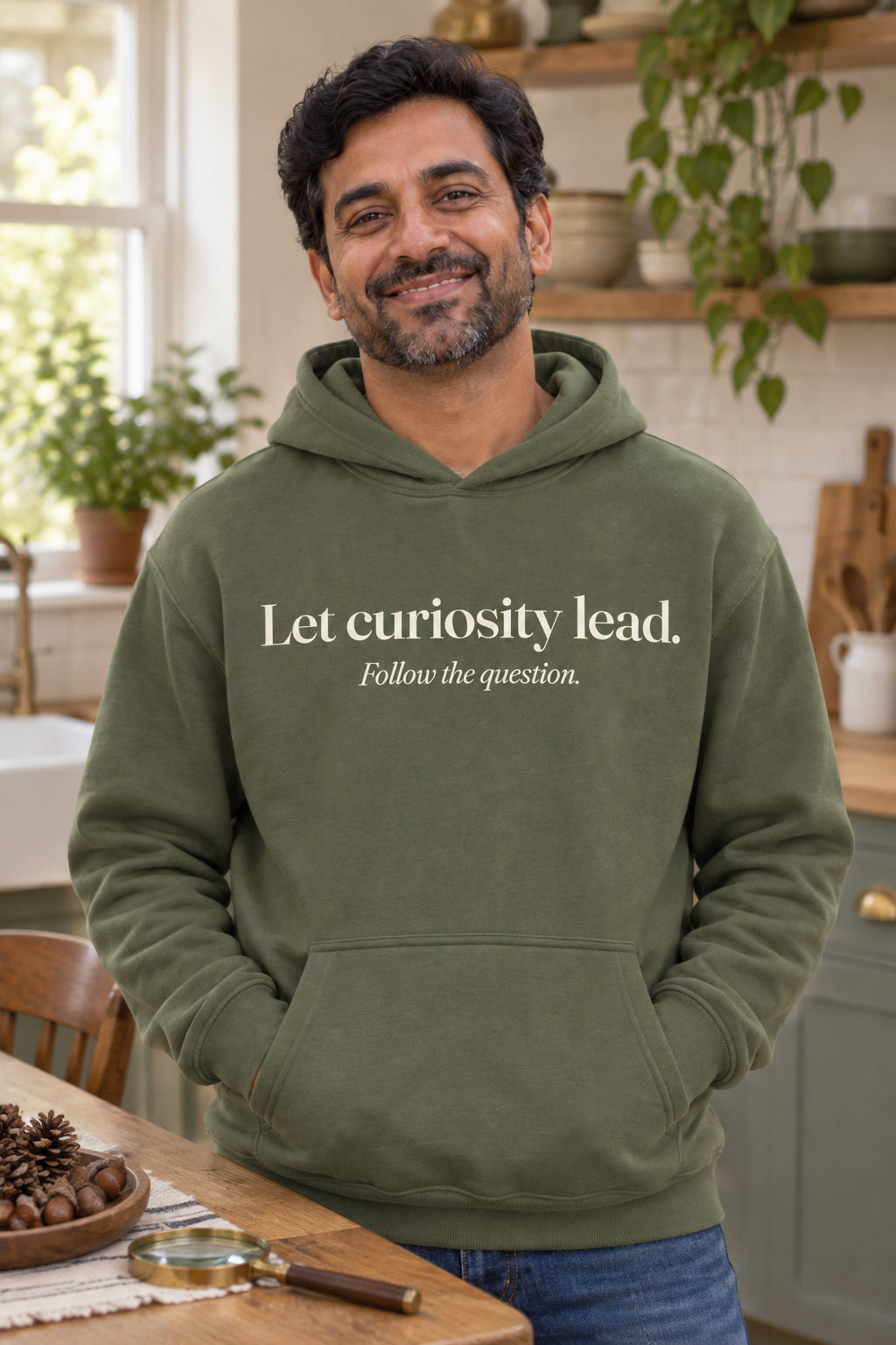 Let curiosity lead. unisex organic cotton hoodie in Moss, front